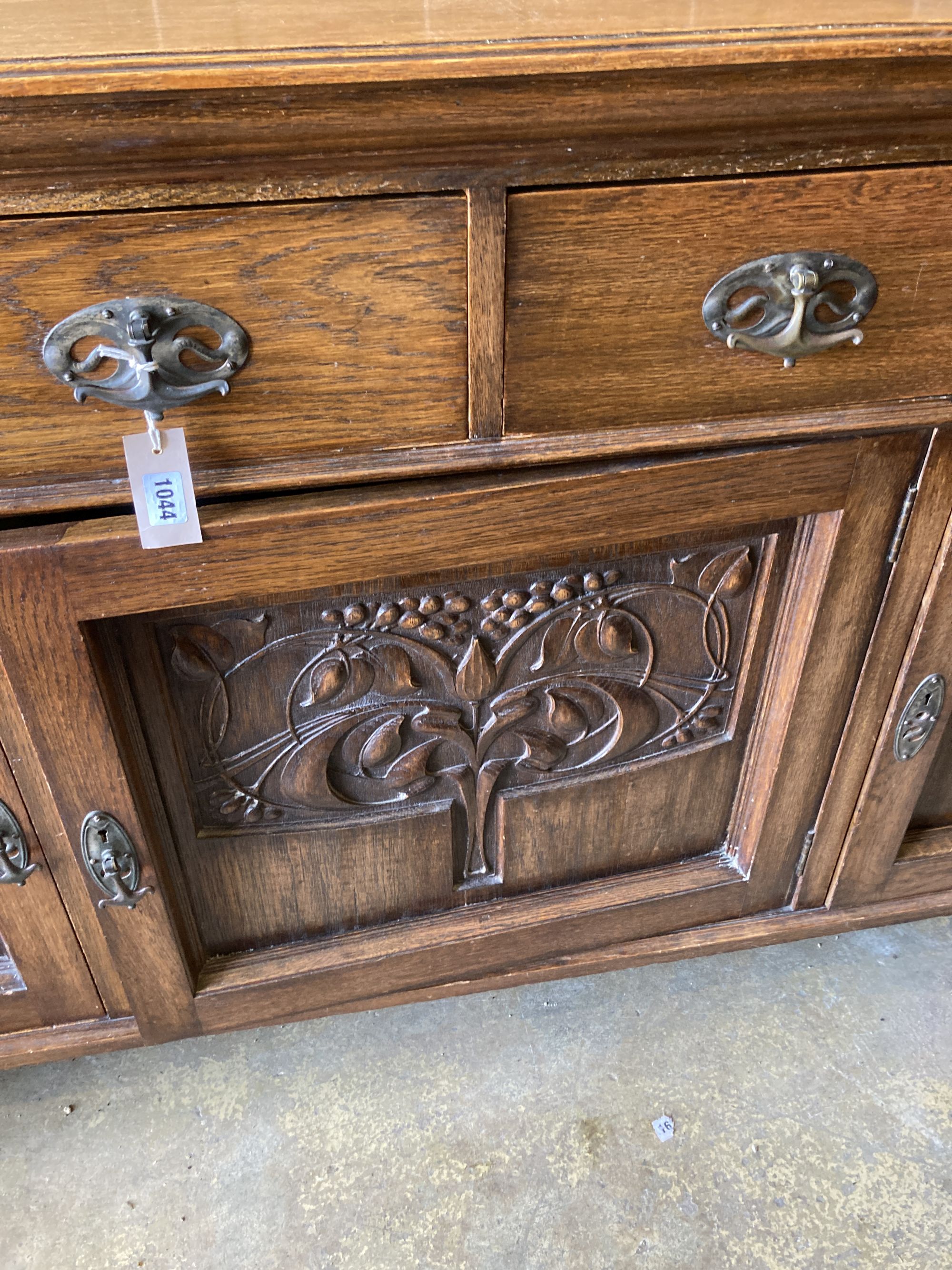 A late Victorian Art Nouveau carved oak sideboard, length 186cm, depth 62cm, height 102cm